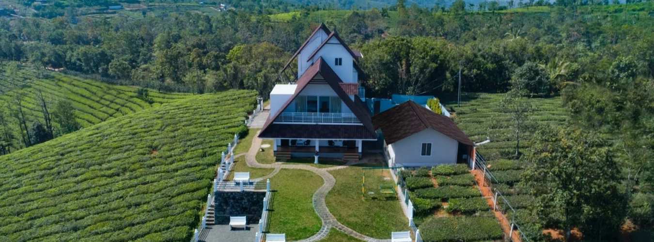 Aerial view of The Highlander private bungalow surrounded by tea plantations in Vattapathal Vagamon