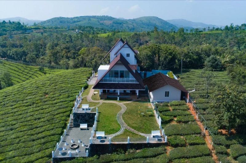 Aerial view of The Highlander resort nestled amidst green tea plantations in Vagamon Kerala