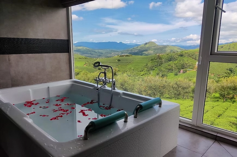 Luxury jacuzzi bathtub with scenic mountain views at The Highlander resort in Vagamon
