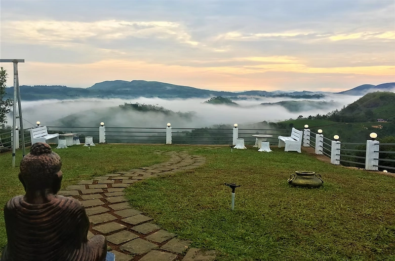 Outdoor balcony seating at The Highlander resort with green valley views in Vagamon Kerala