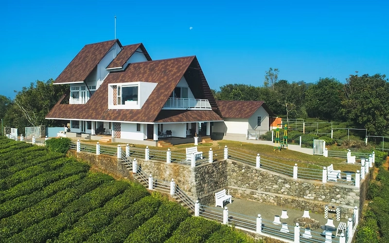 Scenic exterior view of The Highlander resort villa surrounded by lush hills in Vagamon Kerala