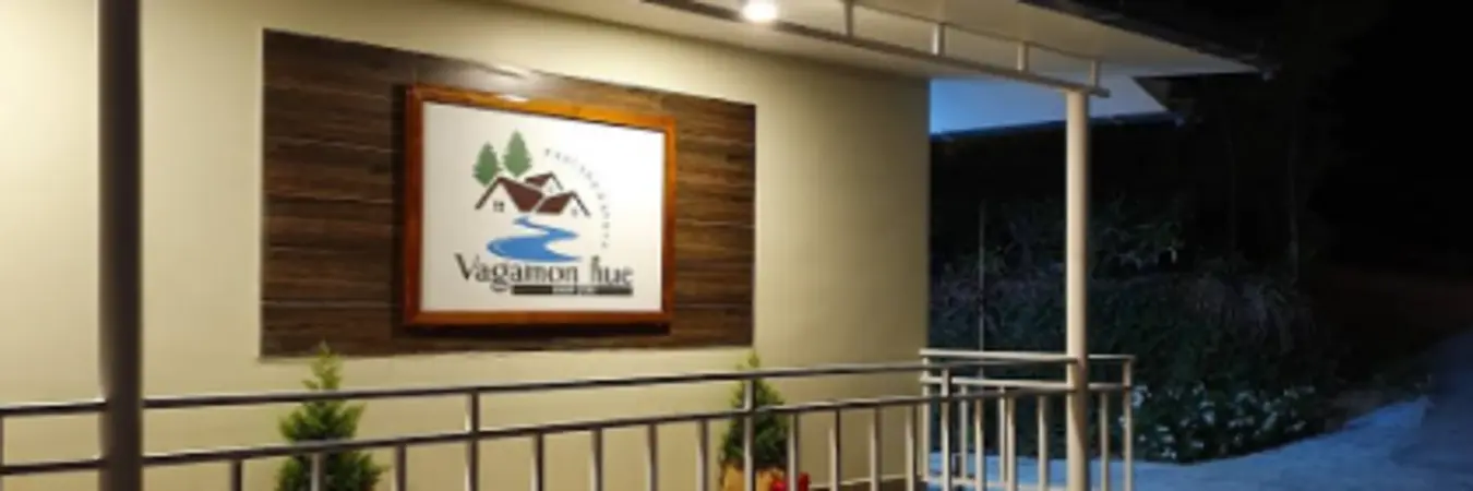 Exterior view of Vagamon Hues farmhouse stay with illuminated signboard along verandah entrance