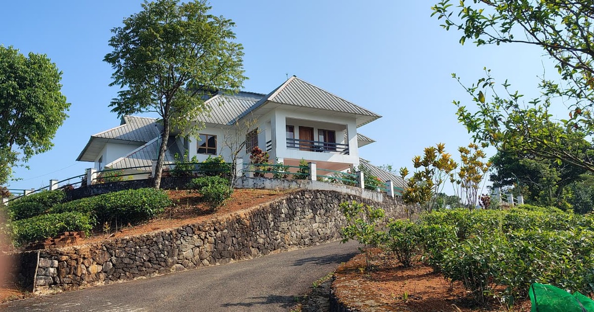 Hilltop view of Zen Garden Wellness Homestay surrounded by tea gardens in Uluppuni Vagamon