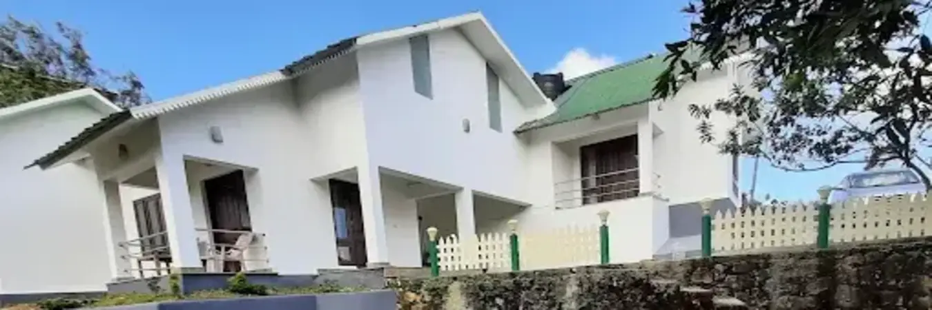Exterior view of white cottage building at Pine View Homestay Kolahalamedu Vagamon