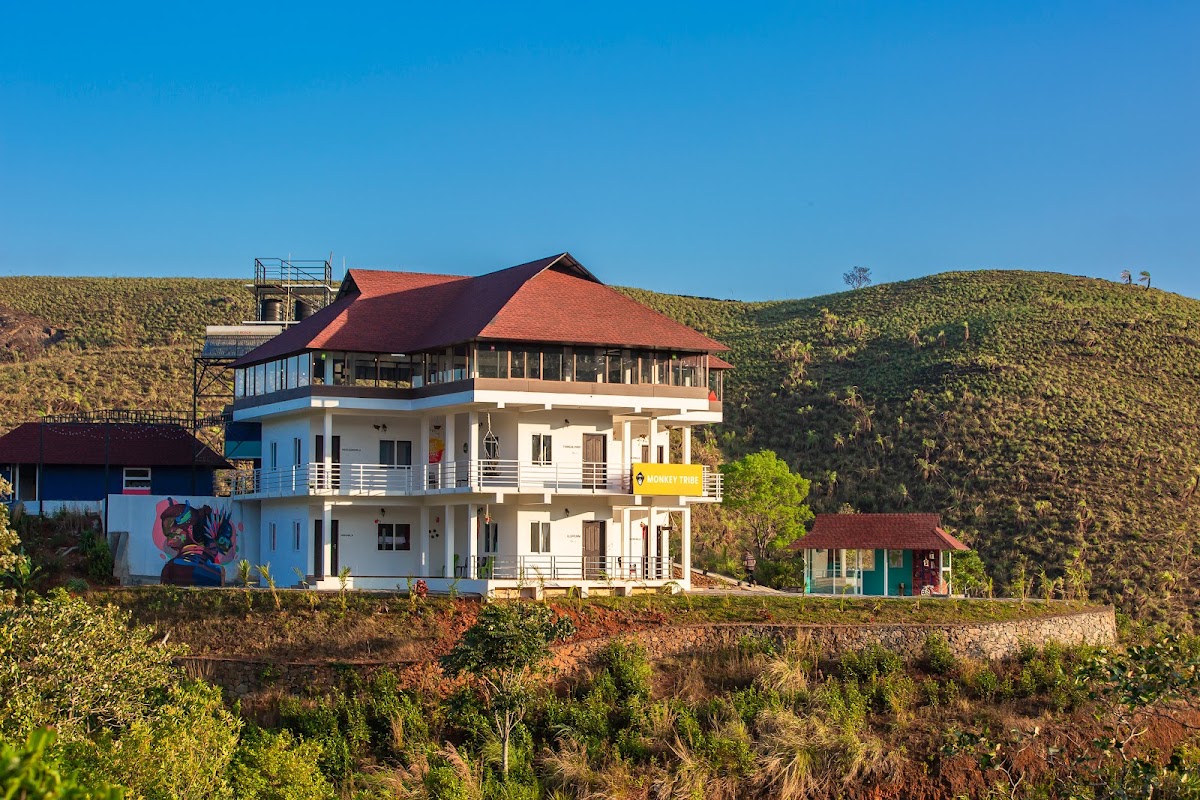 Exterior view of Monkey Tribe Vagamon homestay building on a green hilltop