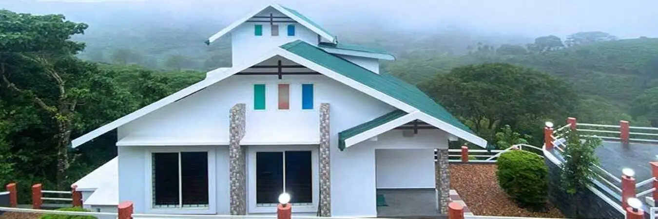 Exterior view of villa cottage with light blue roof surrounded by misty green hills at Angel's Vagamon