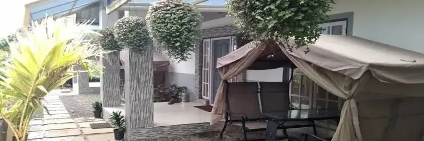 Exterior view of hillside villa building with outdoor seating gazebo at Eagle Rock Holiday Villas Peerumade