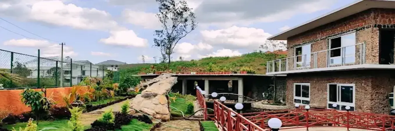 Exterior view of Vaga Copper Castle building set along scenic hill garden in Vagamon