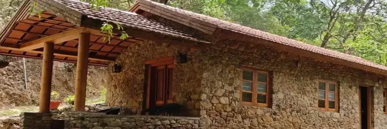 Rustic stone cottage building facade with tiled roof at Mountain Villa Vagamon