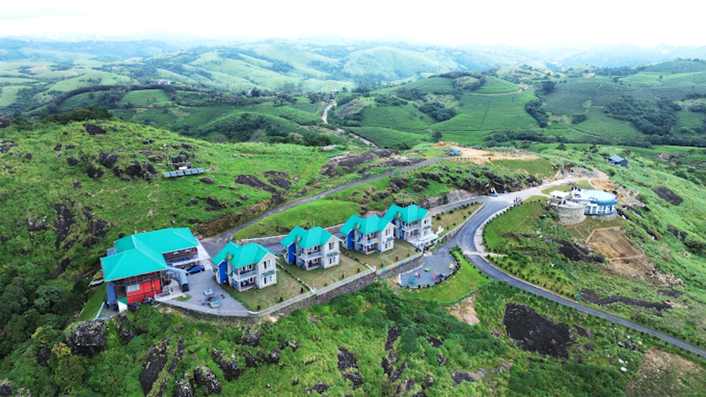Aerial view of Orange Valley Hills Resort perched on green mountain hills surrounded by tea gardens in Vagamon