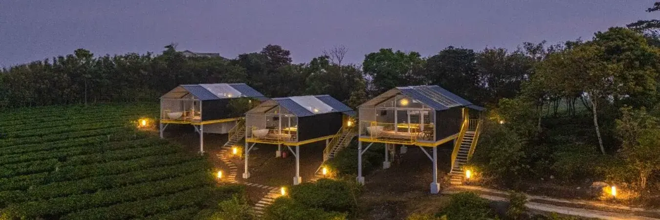 Night exterior view of premium mountain cabins at The Hosteller Bam Vagamon.