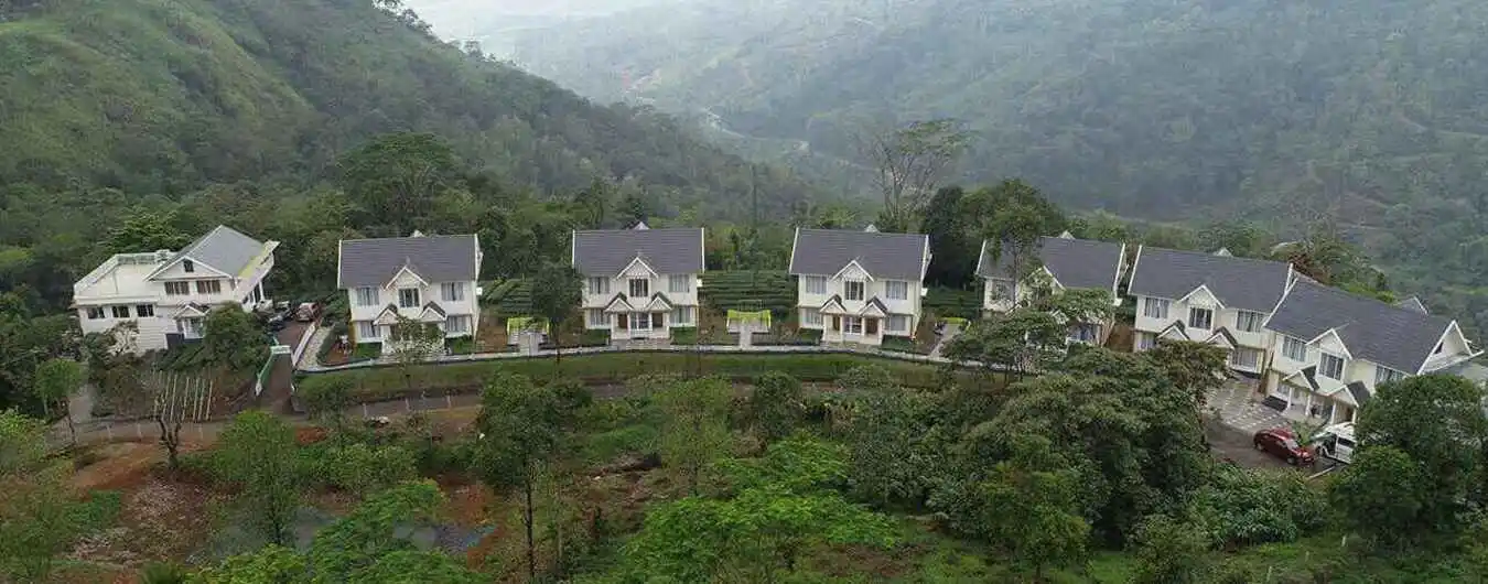 Panoramic hilltop view of luxury white villas at The Grasmere Resort Vagamon