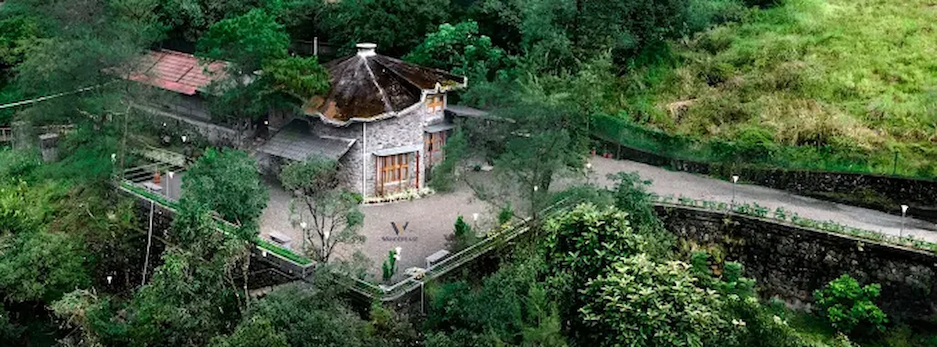 Aerial view of Stone Haven by Wanderease stone cottage surrounded by lush greenery in Vagamon