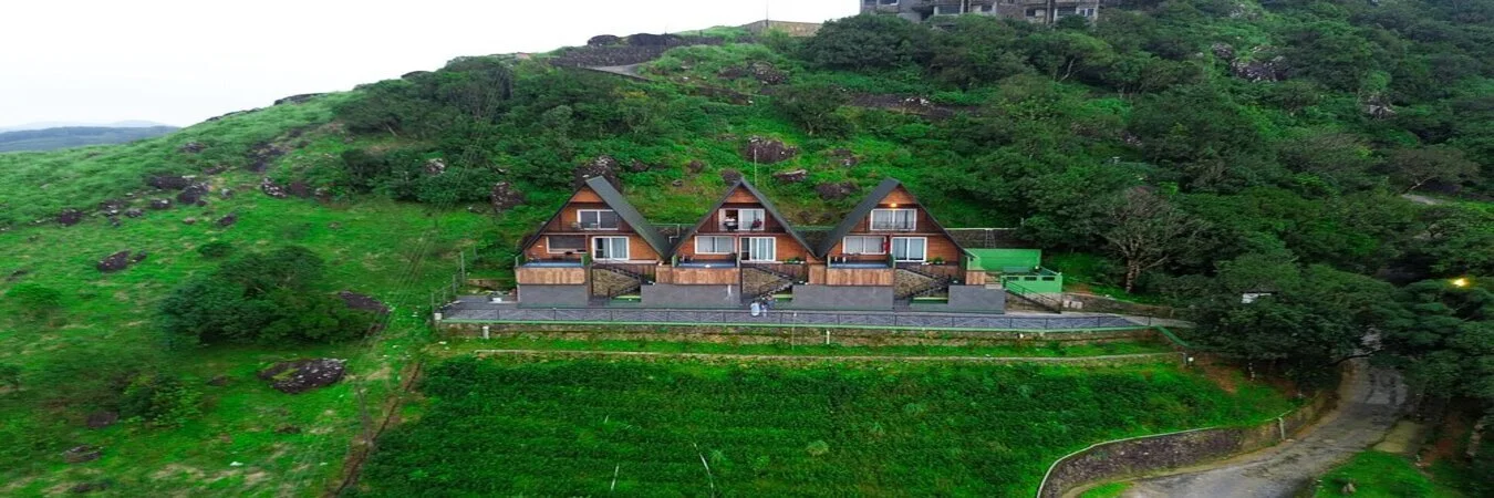 Modern wooden A-frame cabanas with private balconies at Cloud Cabana Holidays Vagamon