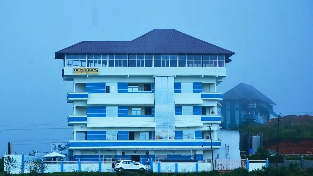Exterior view of modern multi-story Dew Drops Holidays hotel building located in Vagamon town center