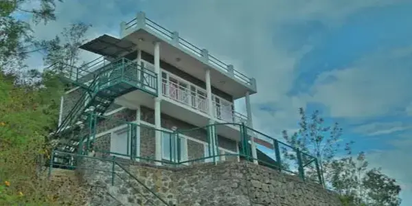 Modern multi-level hill cottage structure with glass balcony deck overlooking mountains at Himaharsham Homestay Vagamon