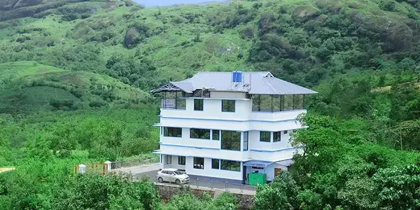 Elevated property view of Snow White Residency set amidst lush greenery and misty hills in Vagamon