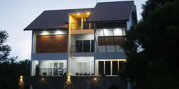 Vagamon Exotica resort building illuminated at twilight with warm outdoor lights