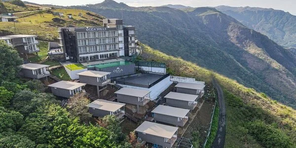 Aerial panoramic view of Olga Resorts nestled on misty mountain slopes in Vagamon Kerala