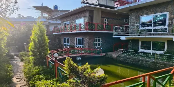 Resort room balcony and stone facade surrounded by lush greenery at Vaga Copper Castle Vagamon