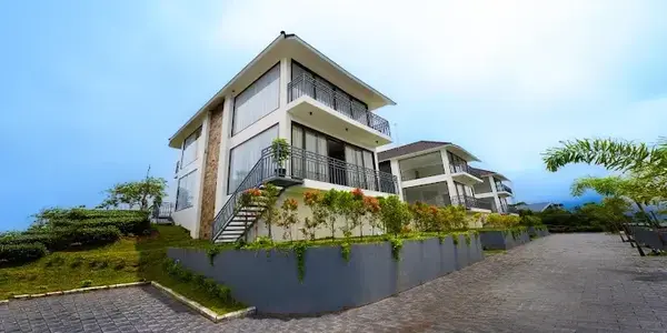 Modern multi-story cottage building with balconies at Golden Meadows Resort Vagamon