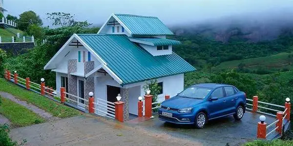 Exterior view of Angel's Vagamon homestay villa with blue car parked on paved driveway