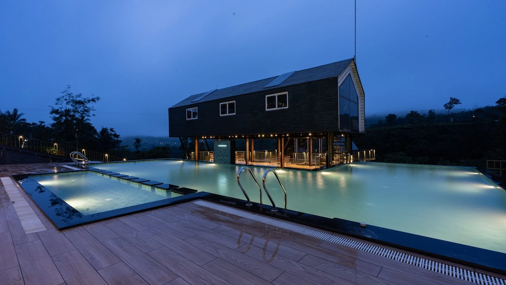 Santuario Resort outdoor infinity pool and luxury stays with evening lighting in Vagamon