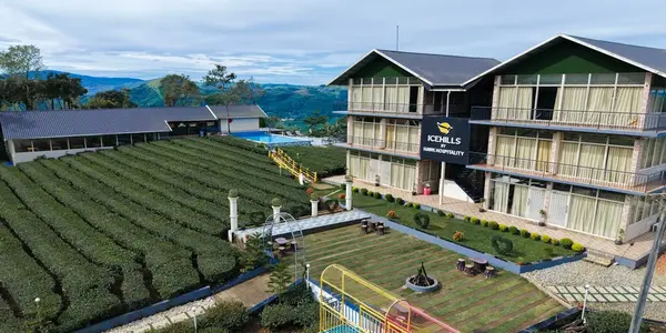 Aerial view of Ice Hills Resort overlooking lush tea plantations and green hills in Vagamon