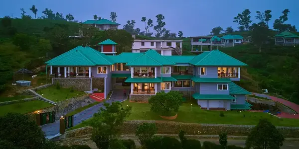 Illuminated front facade of Priyas Villa Vagamon at dusk