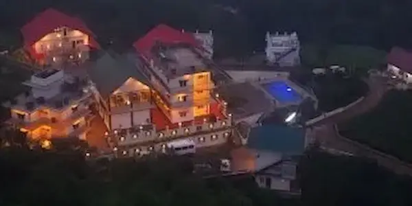 Illuminated night view of Pine Clough Resort building in Vagamon