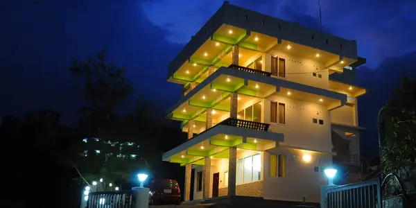 Vaga View Residency exterior brightly illuminated at night against a deep blue sky