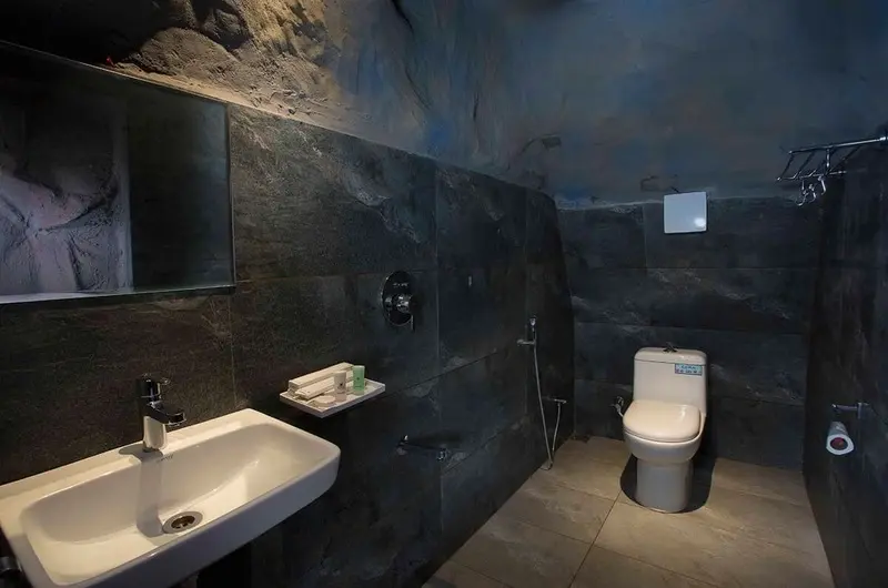 Luxury attached bathroom with sleek dark marble tiles, modern sink, and sanitary fixtures at Foggy Knolls Resort