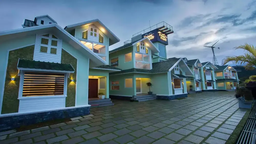 Modern cottage villa exterior with cobblestone pathway and warm exterior lighting at Foggy Knolls Resort