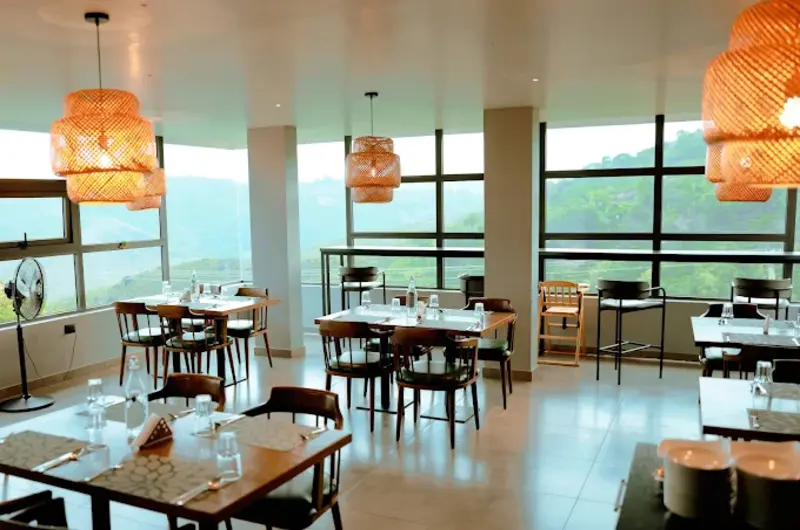 Spacious indoor restaurant dining hall with modern tables and large floor-to-ceiling landscape windows