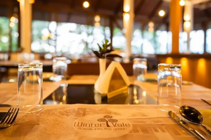 Warm wooden restaurant dining area with elegant lighting at Winter Vale Green Stay