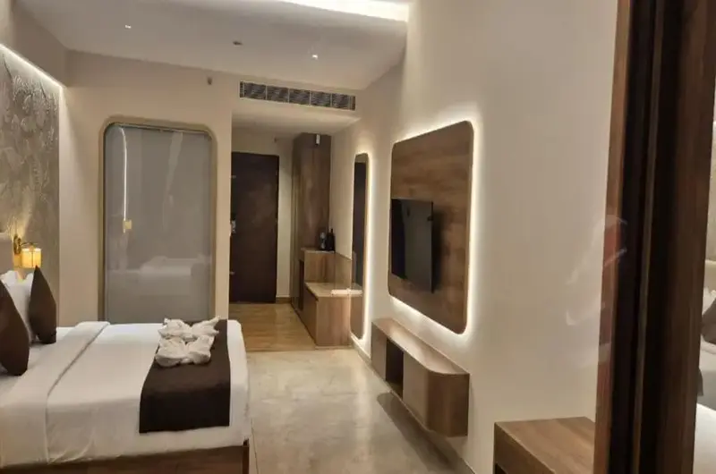 Modern luxury suite bedroom with elegant wall paneling, comfortable bedding, and warm ambient lighting