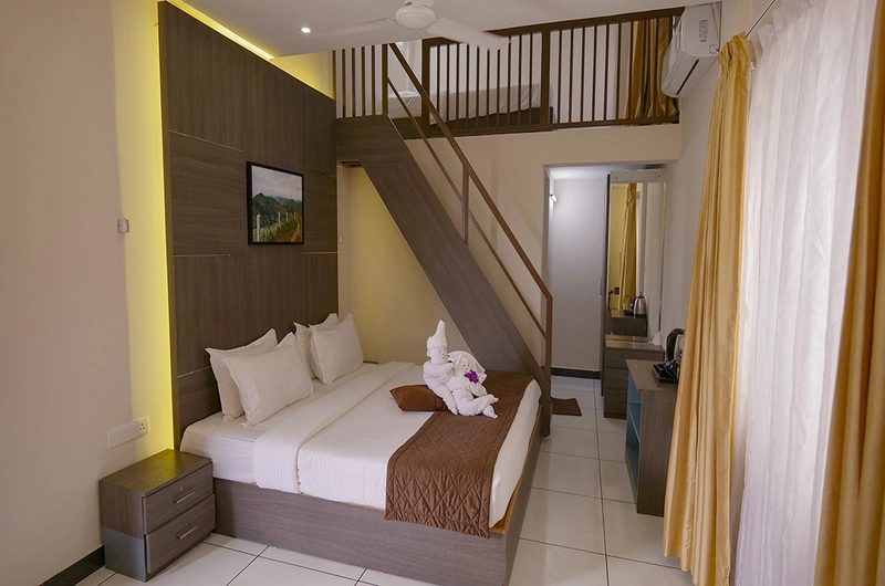 Spacious duplex loft suite interior featuring a wooden staircase and cozy upper sleeping area at Palette Hill View Resort