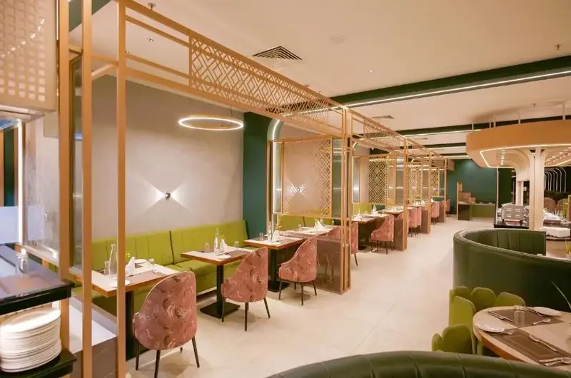 Spacious resort restaurant dining hall with wooden tables and modern lighting at Palette Hill View Resort