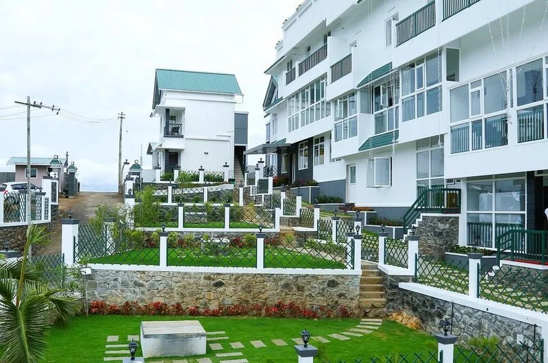Multi-story resort building with manicured front lawn and stone pathway at Palette Hill View Resort