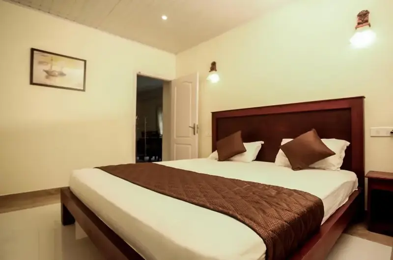 Deluxe guest bedroom suite featuring a wooden double bed with dark runner and ambient lighting