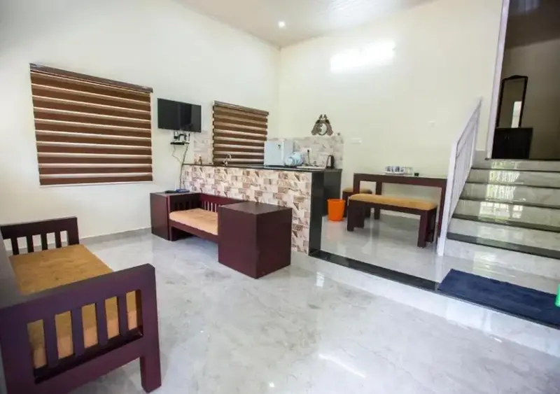 Spacious cottage guest room with comfortable double bed, wooden seating, and large windows at Lavender Plantation Stay