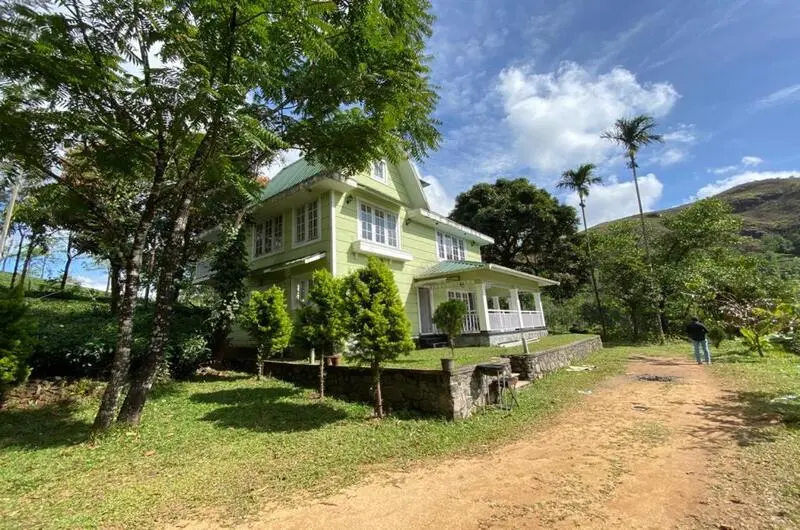 Scenic driveway and lawn area surrounding green cottage structure at Lavender Plantation Stay