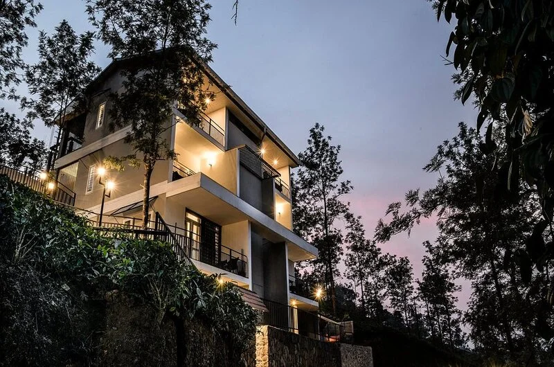 Evening dusk view of illuminated resort cottage architecture surrounded by trees at Falcon Crest Resort