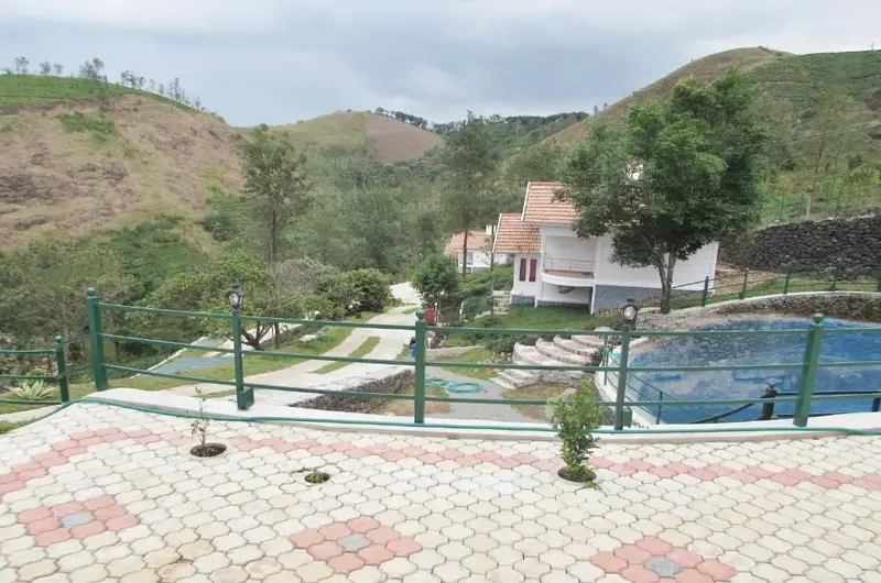 Outdoor swimming pool with paved sun deck and mountain backdrop at Falcon Crest Resort Vagamon