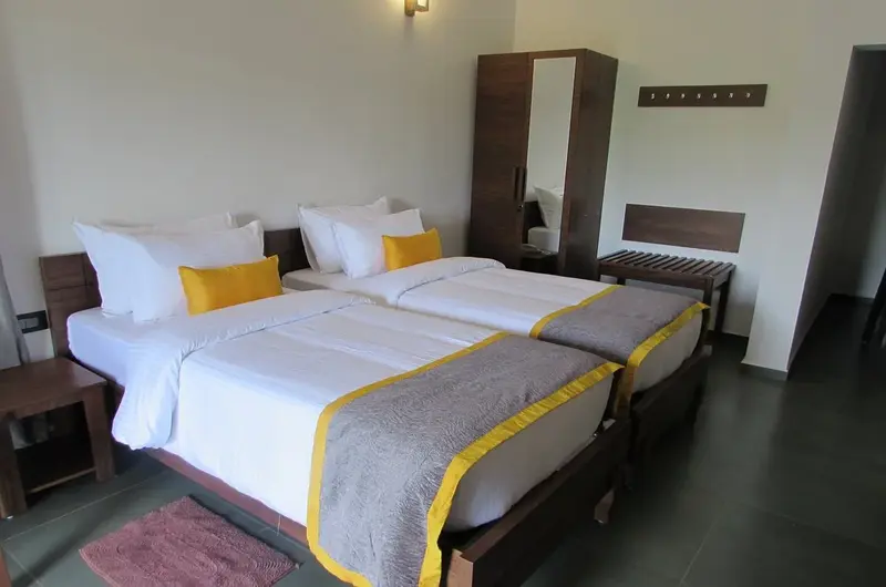 Cozy resort guest room featuring twin double beds with yellow throw runners and bedside tables at Falcon Crest Resort