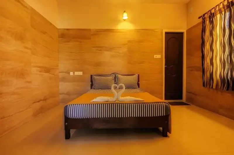 Decorated honeymoon suite bedroom with swan towel art, plush bed, and warm wooden paneling at Green Palace Residency