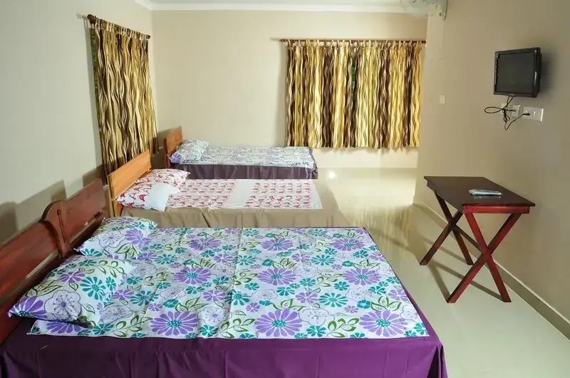 Cozy family room suite featuring multiple beds with patterned bedsheets and bedside tables