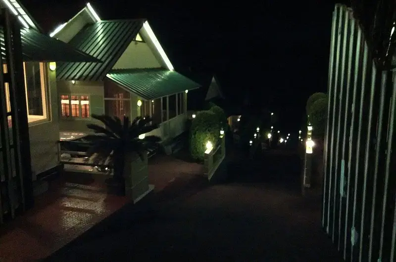 Nighttime exterior view of Green Palace Residency building illuminated with warm ambient lighting