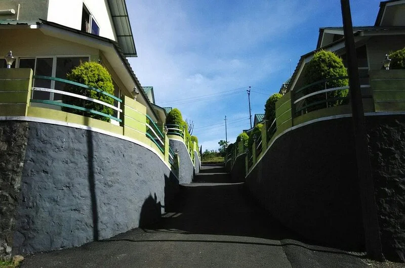 Paved entrance pathway and stone steps leading to guest suites at Green Palace Residency