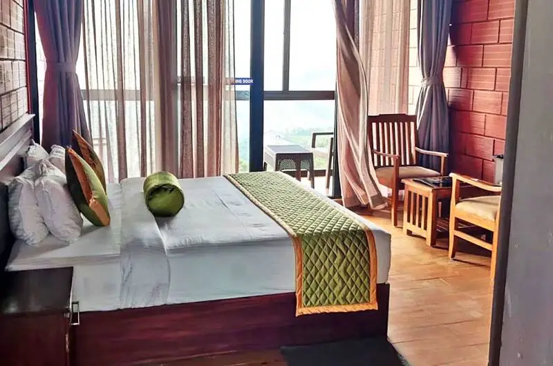 Spacious bedroom suite at Orange Valley Hills Resort with modern decor, warm lighting, and private hill view